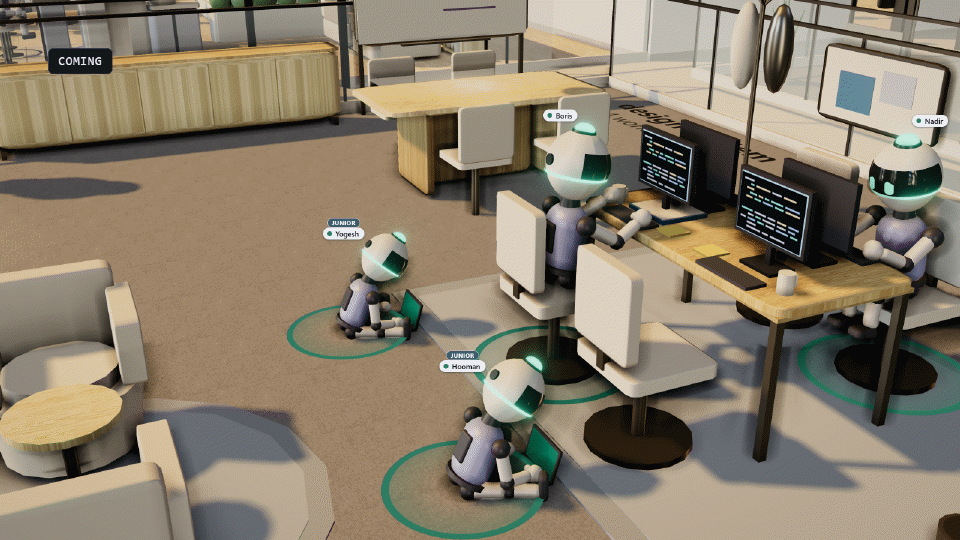 A close view of the 3D office: two round robots at a desk with terminals on their monitors, and two smaller ones sitting on the floor with laptops under tags that read Junior. A label in the corner reads Coming.